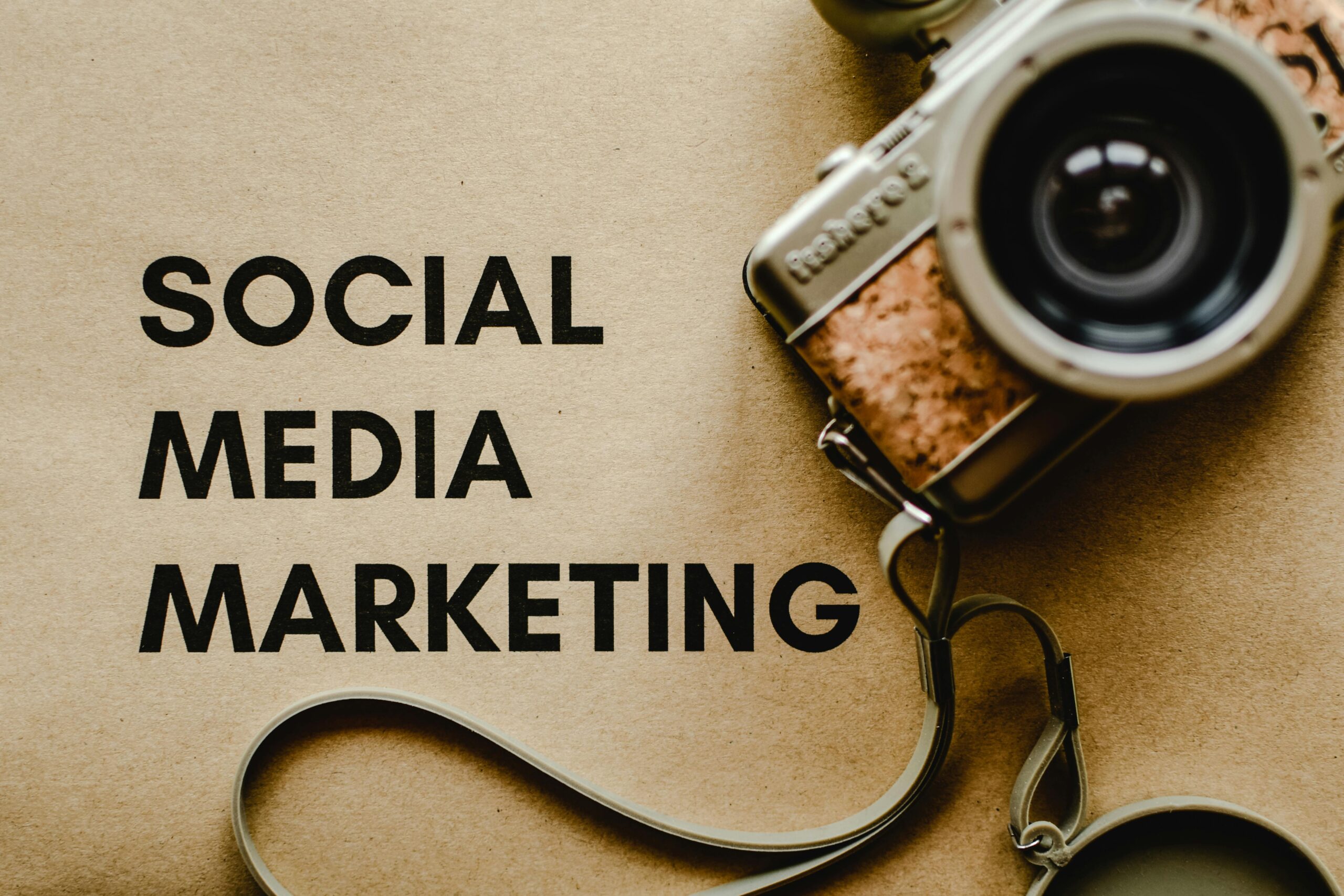 A vintage camera on brown paper with 'SOCIAL MEDIA MARKETING' text, perfect for marketing visuals.